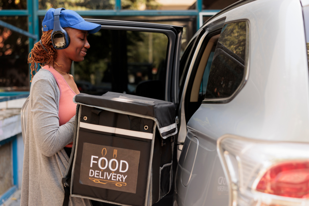 An employee delivering food showcasing the importance of hired & non-owned auto insurance for restaurant success.